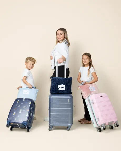 Parent and two kids with EverSnug pillows clipped to three suitcases