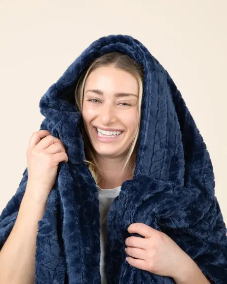 Creator laughing wrapped in the navy EverSnug blanket